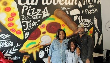 Photo of Eleven-year-old Sebastian Wilson serves ‘Spices & Slices’ at Caribbean style pizza shop in Brooklyn