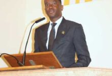 Photo of PM Mitchell honors Dr. Roland Purcell at packed funeral