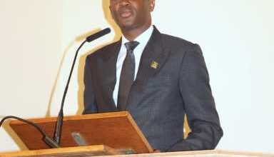 Photo of PM Mitchell honors Dr. Roland Purcell at packed funeral